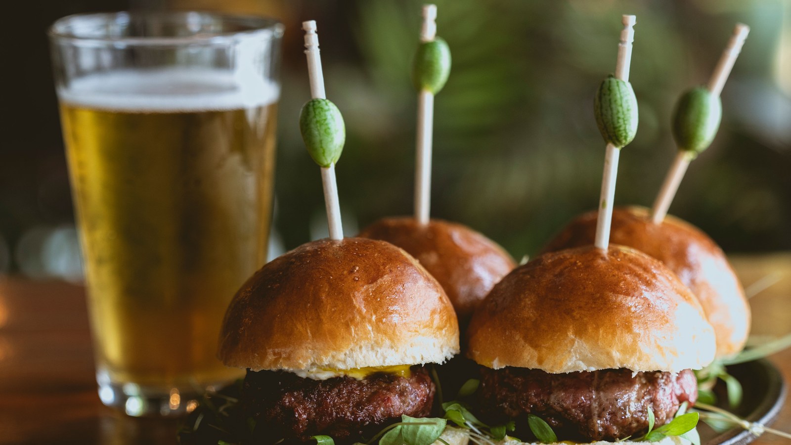 Illustrative stock photo of beef sliders beside a draft beer.
