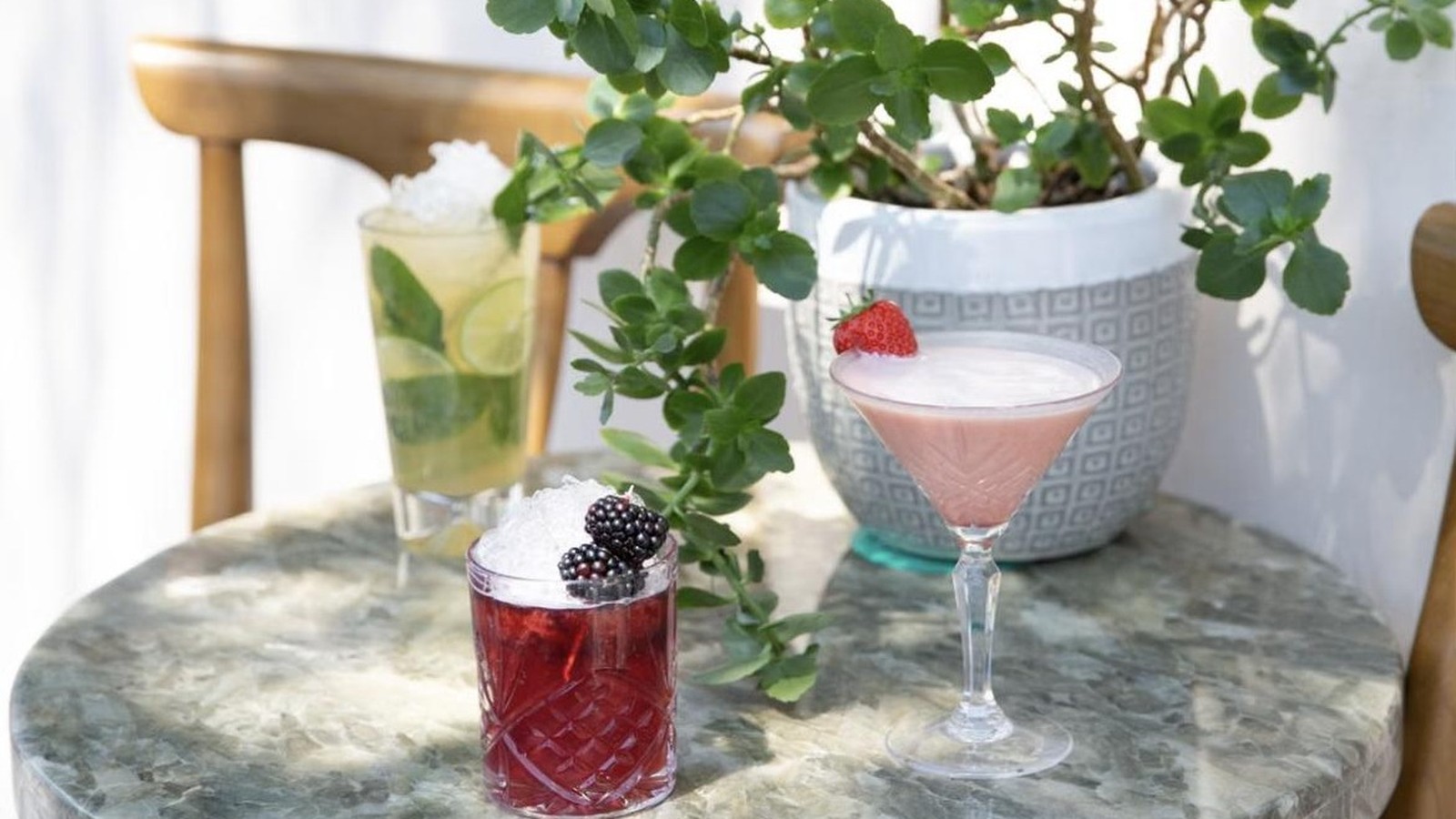 Illustrative stock photo of colorful cocktails on a marble table.