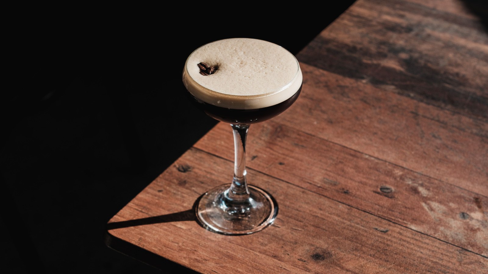 Illustrative stock photo of an espresso martini on a dark wood table.