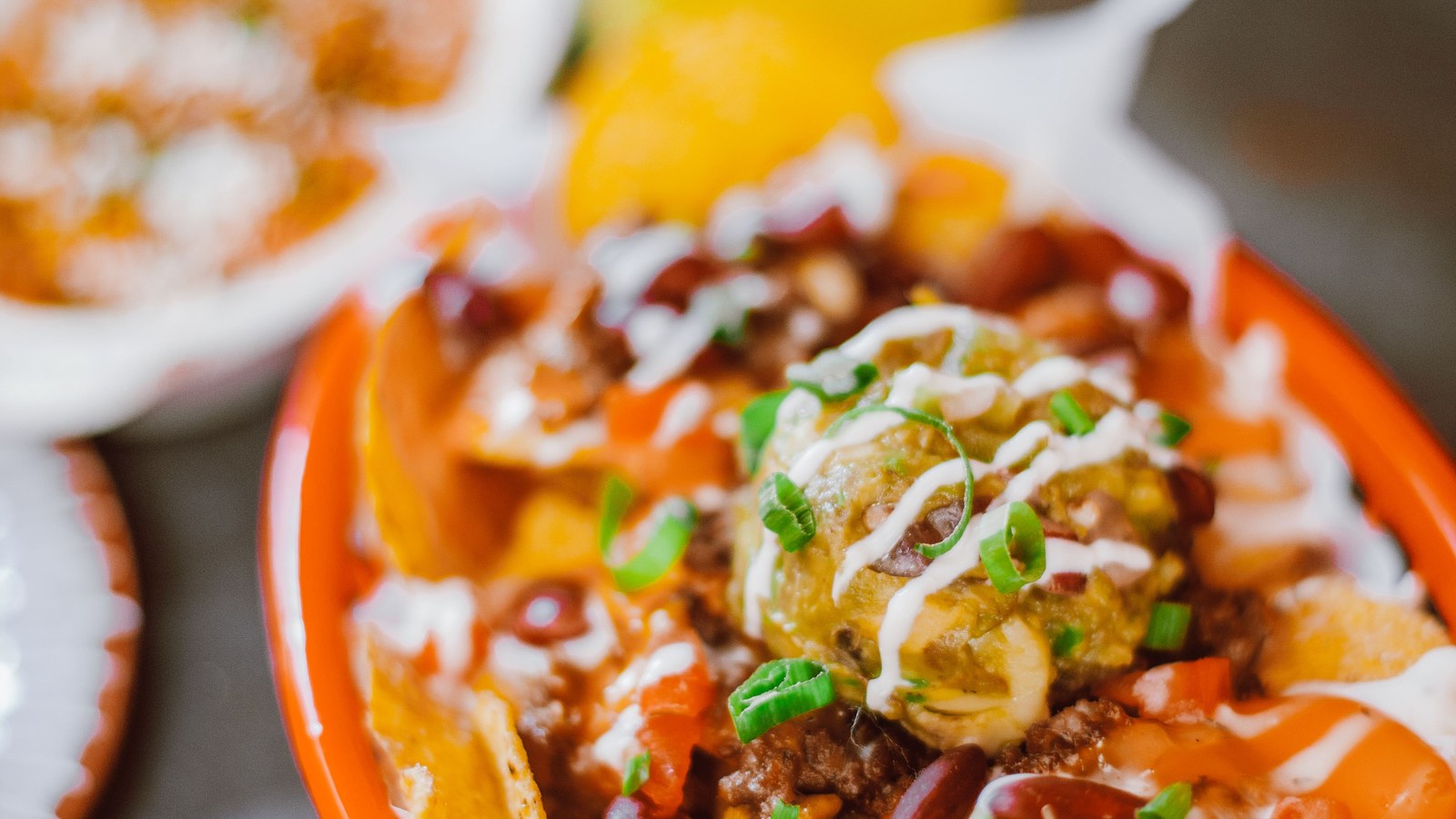 Illustrative stock photo of loaded nachos with a cocktail nearby.