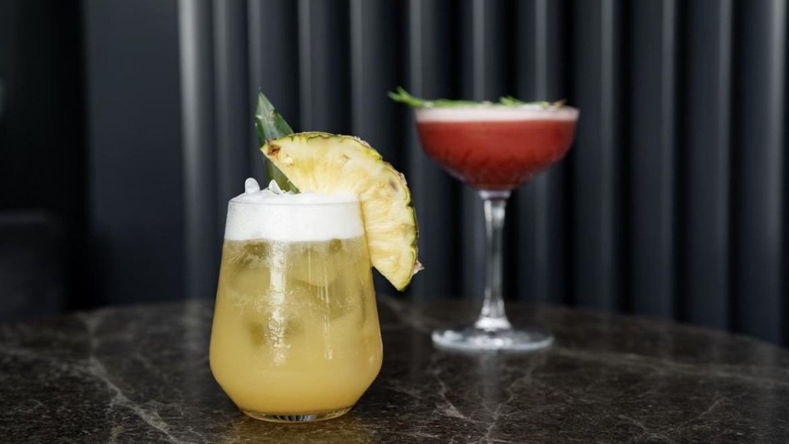Illustrative stock photo of a pineapple cocktail in a dark bar.